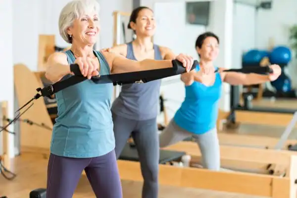 Toning Arms After 60: Empowering Womens Fitness Through Effective Weight Training 2 older woman doing weight training Canvey Island and resistance in the gym to tone upper arms