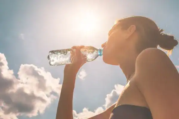 Hydration: The Secret Ingredient for a Toned Stomach and Enhanced Fitness 3 Image of woman drinking water to hydrate Canvey Island after run.
