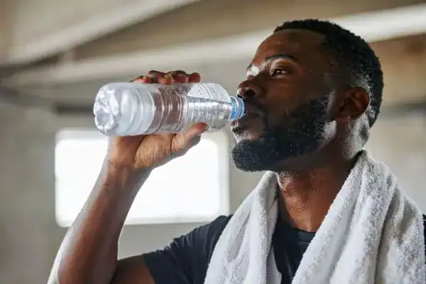 Hydration: The Secret Ingredient for a Toned Stomach and Enhanced Fitness 1 Image of man drinking water to improve hydration Canvey Island after work out.
